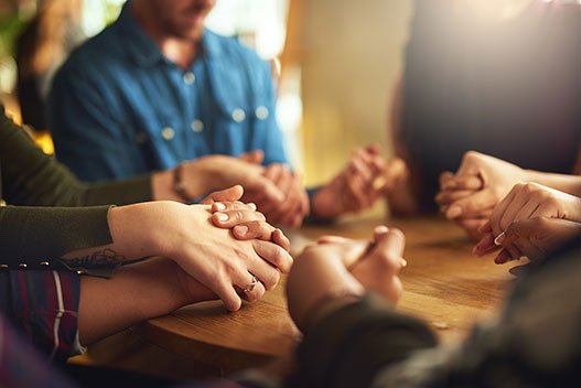 people holding hands praying